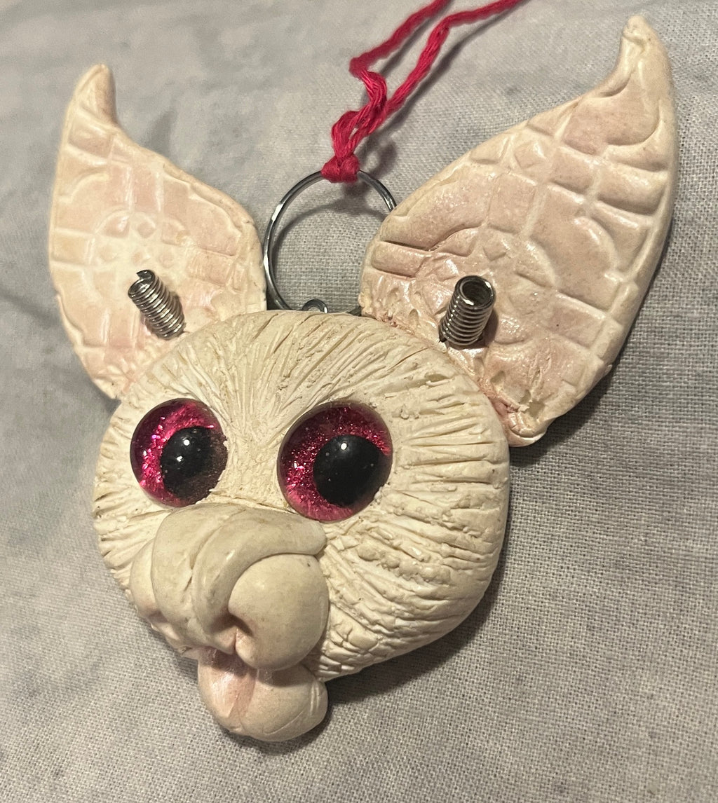 Lilly sculpted bat pendant, angled view showing textured ears and pink glass eyes