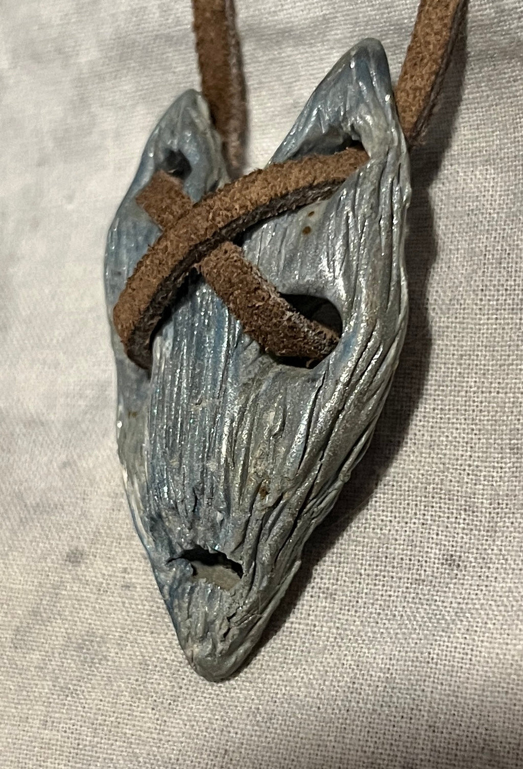 The Relic wearable curiosity, side view showing sculpted depth and cord construction