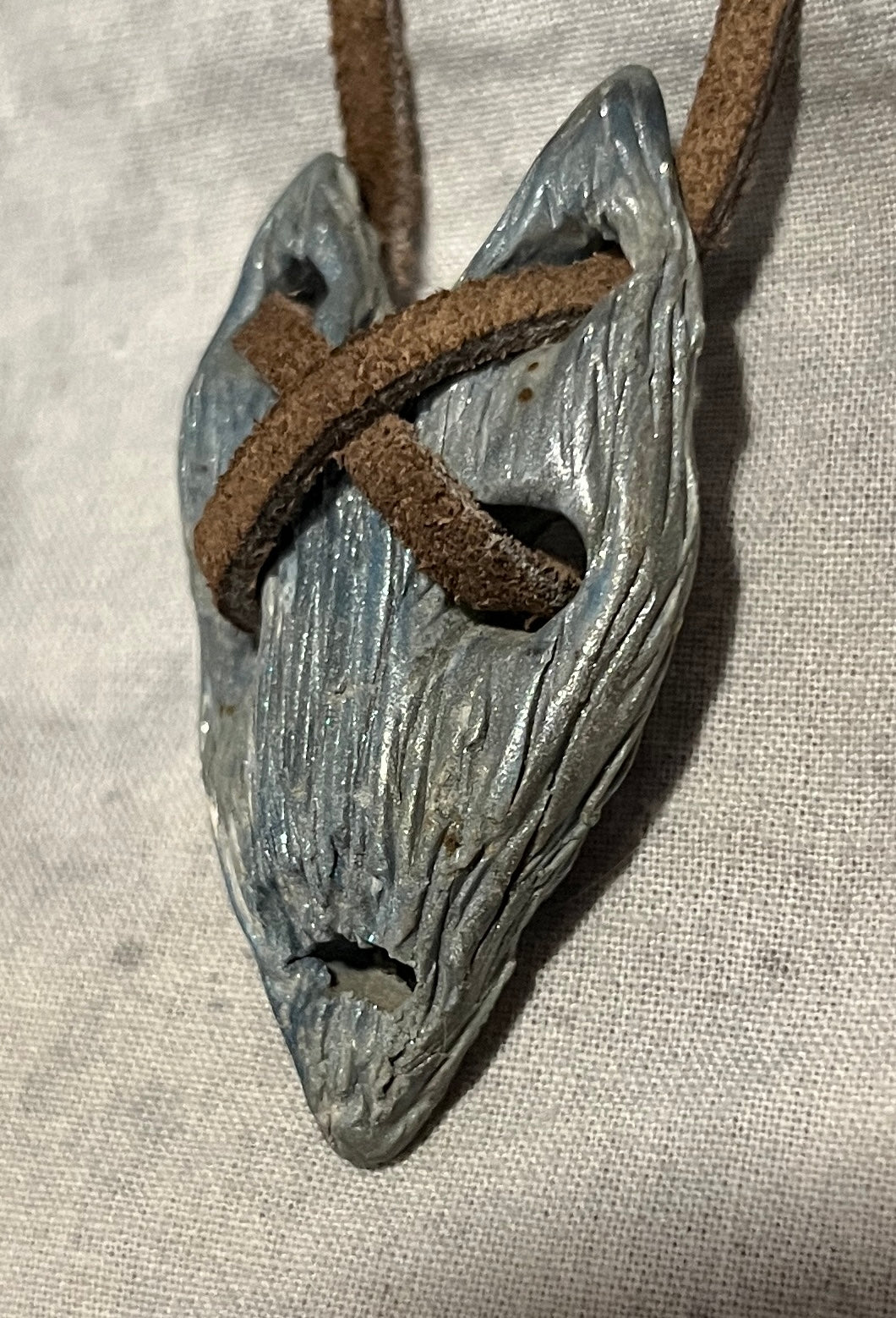 The Relic wearable curiosity, side view showing sculpted depth and cord construction